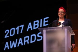 Dr. Sue Black OBE stands behind the podium in front of a screen that says "2017 ABIE Awards" 