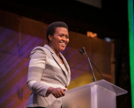 ABIE Award Winner Marie Claire Murekatete smiling on the main stage during the GHC 17 Thursday Keynote