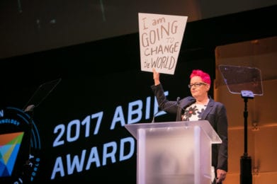 ABIE Winner Dr. Sue Black OBE holds up her I AM statement on the main stage: "I AM going to change the world."