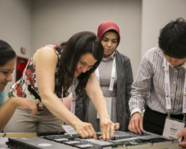 A group of women work on a project at the GHC 18 Open Source Day
