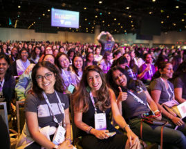 Audience members smile at the GHC 19 Opening Keynote