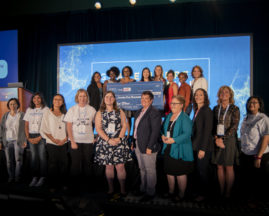 Dr. Sanna Gaspard holds her check on stage next to Brenda Darden Wilkerson and the judges after winning the 2019 AnitaB.org PitcHER competition