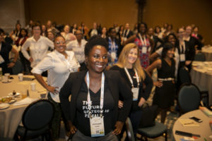 Women of color striking a power pose at GHC 19